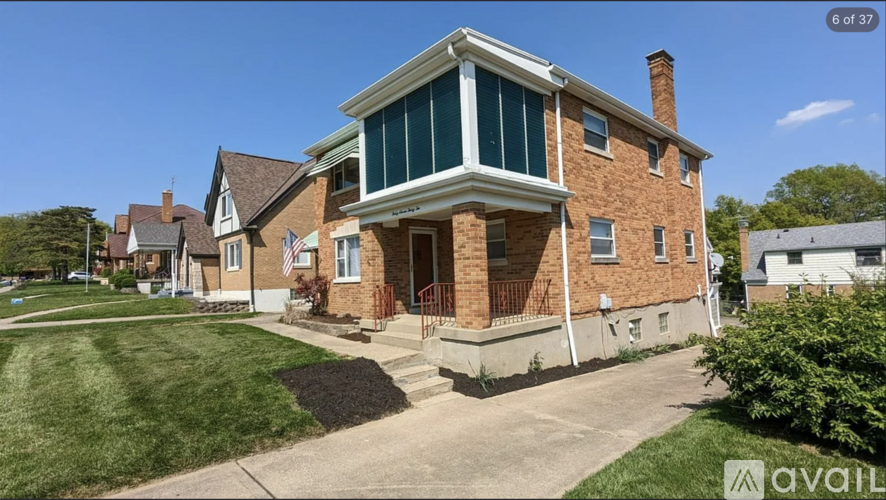 A house with a brick facade and a large front porch is for sale.