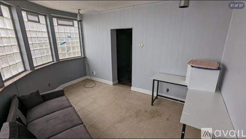 A living room with a grey couch and a black door.