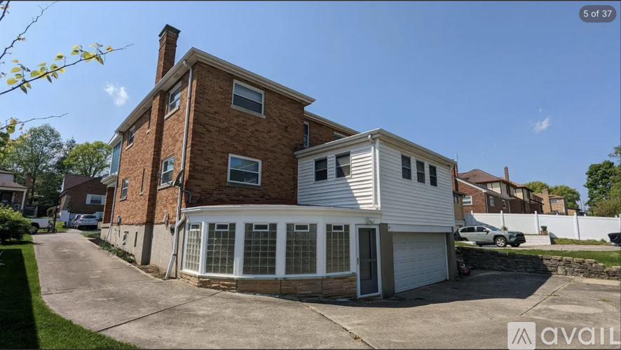 A house with a brick chimney and a white garage door.