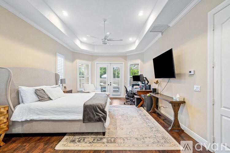 A bedroom with a large bed and a flat screen TV mounted on the wall.