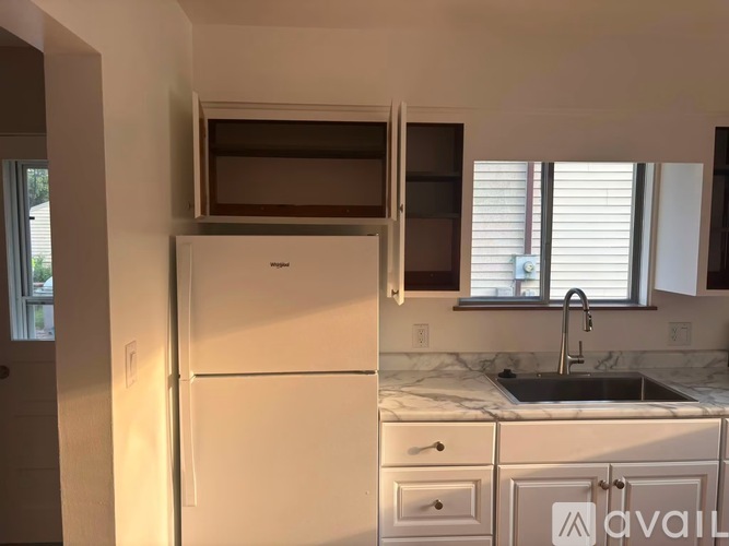 A kitchen with a white fridge and a marble counter top.
