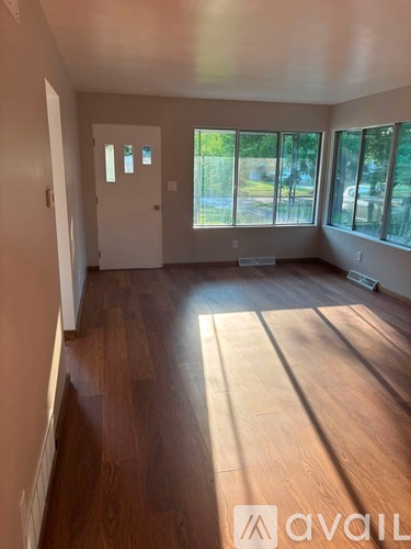 A room with wooden floors and a large window.
