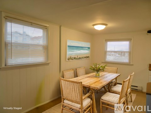 A dining room with a wooden table and chairs.