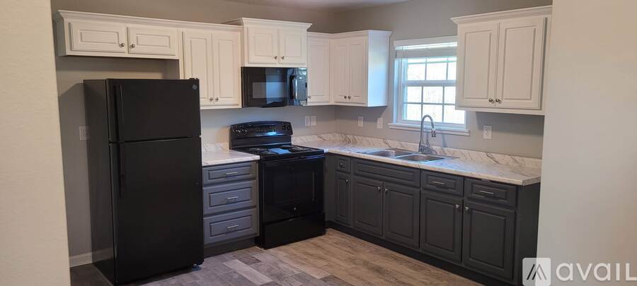 A kitchen with black appliances and cabinets.
