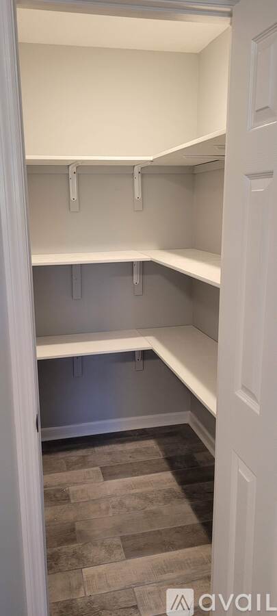 Empty white shelves in a room with a tiled floor.