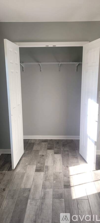 A room with a grey wall and a wooden floor.