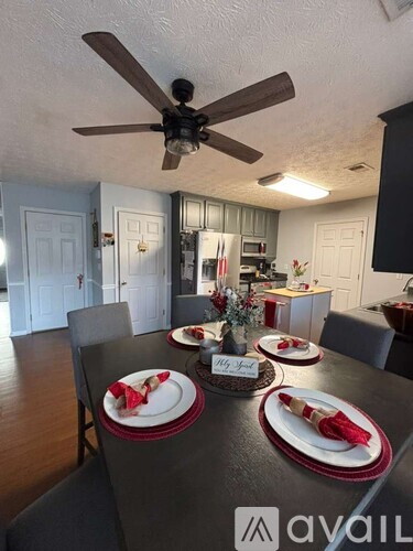 A dining room with a table set for a meal.