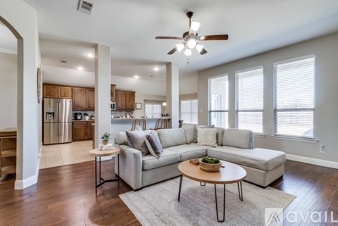A spacious living room with a grey sofa and a wooden coffee table.