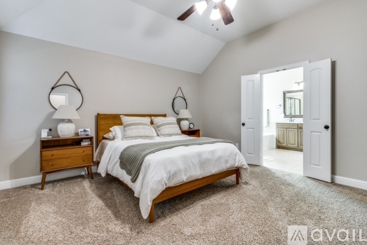 A bedroom with a large bed and a ceiling fan.