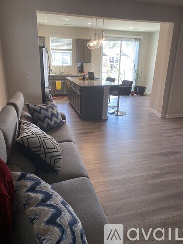 A living room with a grey couch and a wooden floor.