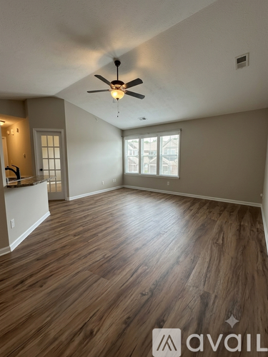 A room with wooden flooring and a ceiling fan.