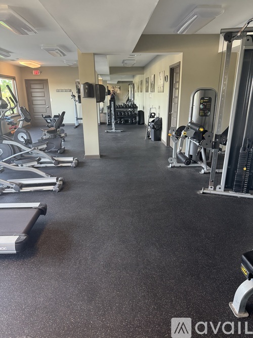 A gym with a variety of equipment including treadmills, weights, and exercise machines.