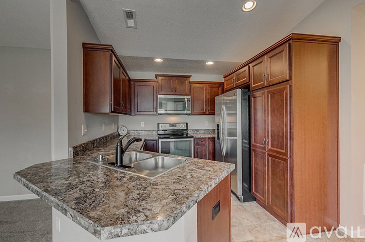 A kitchen with granite countertops and wooden cabinets.
