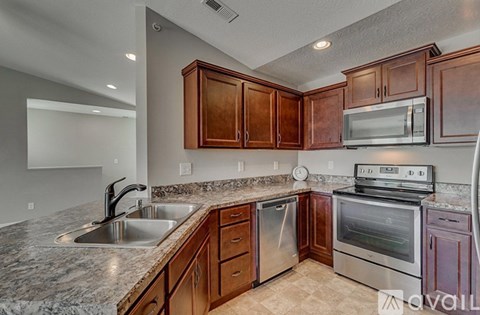 A kitchen with brown cabinets and stainless steel appliances.
