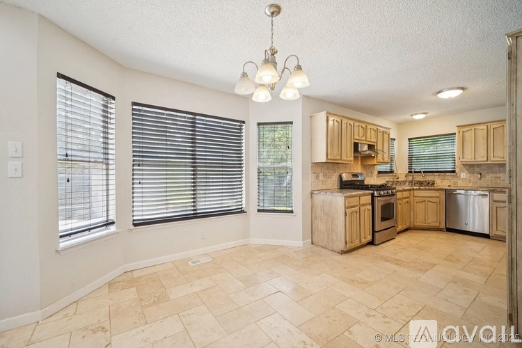 A kitchen with wooden cabinets and a tile floor.