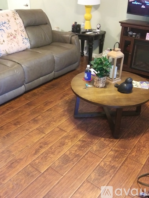 A living room with a grey couch, a wooden coffee table, and a lamp.