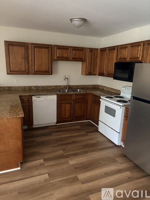 A kitchen with wooden cabinets and white appliances.