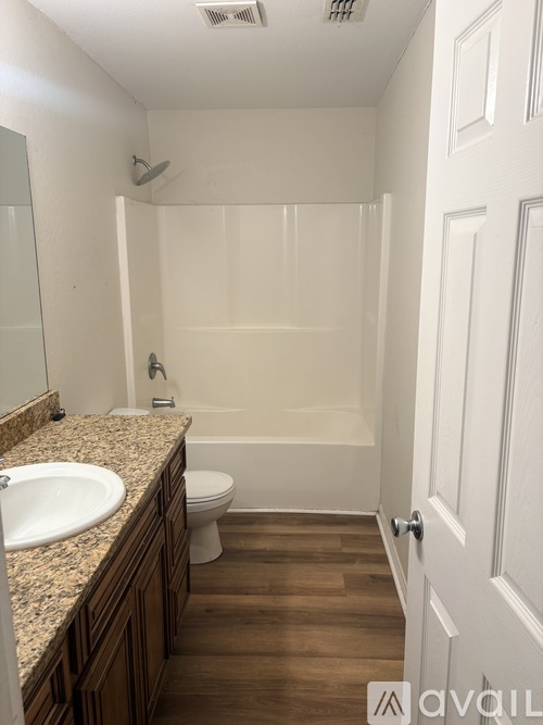 A bathroom with a sink, toilet, and bathtub.