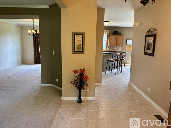 A room with a vase of flowers on the floor.