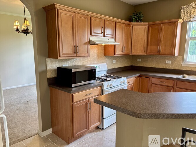 A kitchen with wooden cabinets and a black stove top oven.