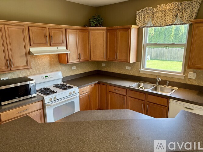 A kitchen with wooden cabinets and a white stove top oven.