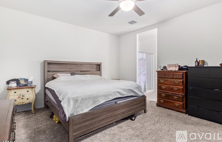 A bedroom with a bed, dresser, and nightstand.