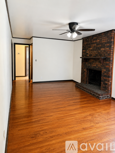 A room with a fireplace and a ceiling fan.