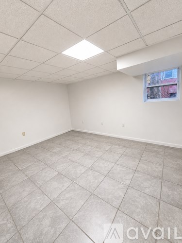 A room with white walls and a window with a view of a building outside.