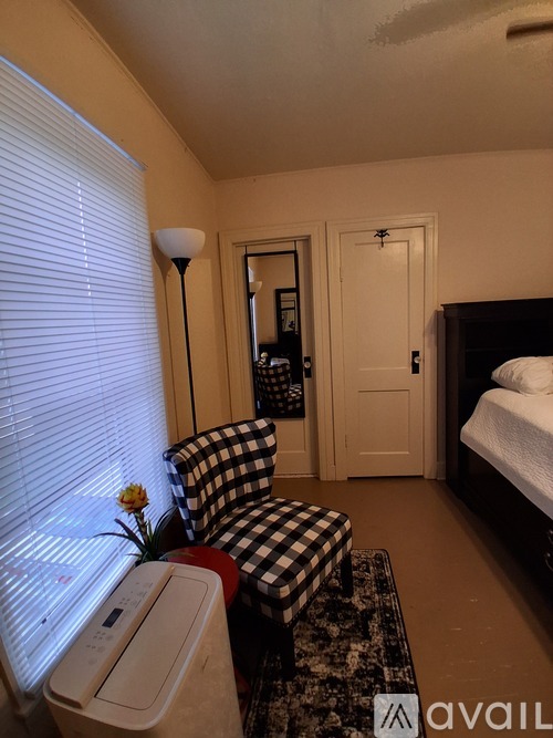 A bedroom with a bed, dresser, chair, and mirror.