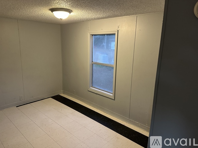 A room with a window and a tiled floor.