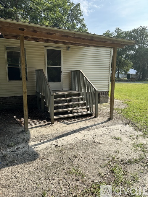A small house with a porch and a staircase leading to the door.