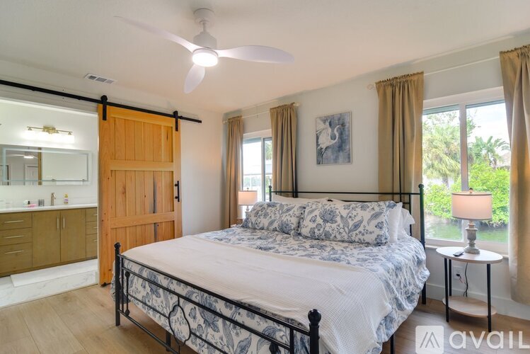 A bedroom with a large bed and a ceiling fan.