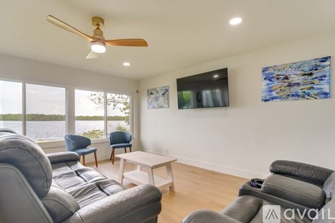A living room with a grey sofa and a ceiling fan.