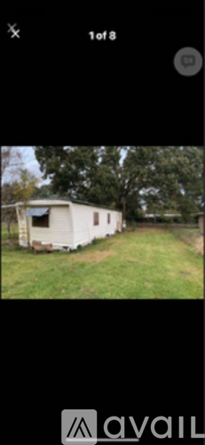 A white trailer is parked in a grassy area.
