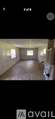 A room with wooden flooring and a window.
