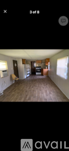 A room with wooden flooring and a white wall.