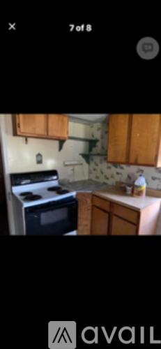 A kitchen with wooden cabinets and a black stove top oven.