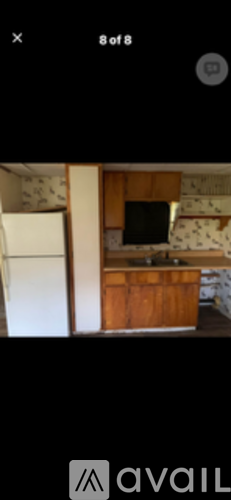 A kitchen with a refrigerator and a television.