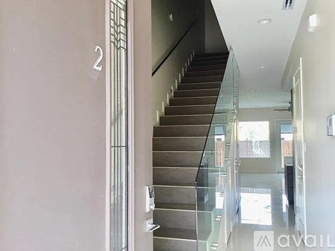 A staircase with a glass railing and a number 2 on the wall.