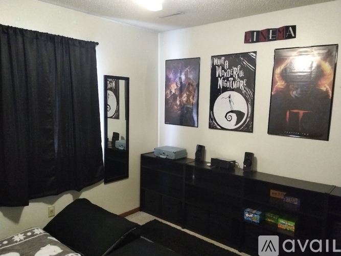 A black and white photo of a movie poster is on the wall above a black speaker.