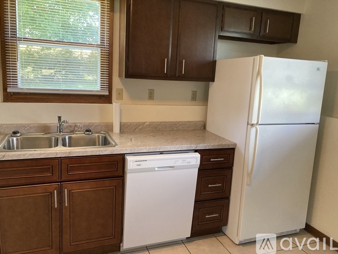 A kitchen with brown cabinets and a white fridge.