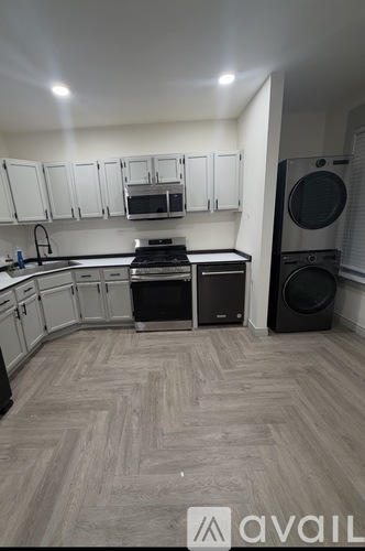 A kitchen with white cabinets and a wooden floor.