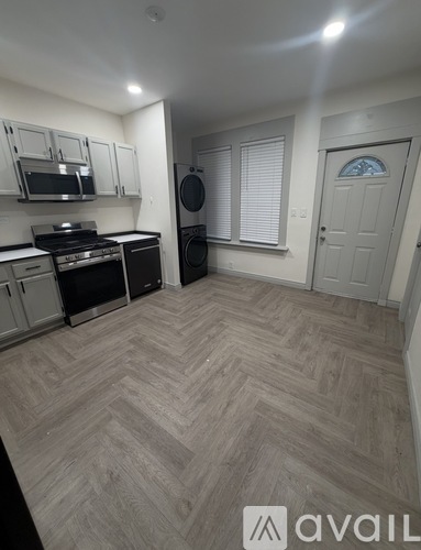 A kitchen with a washing machine and a microwave.
