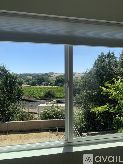 A view from a window looking out to a landscape with trees and a clear sky.