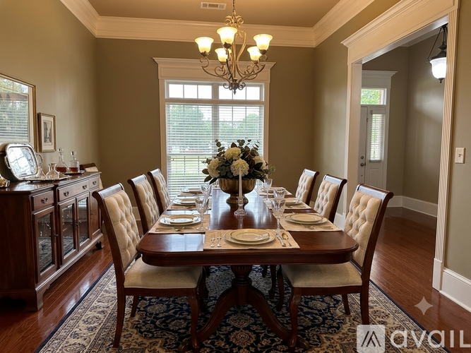 A dining room with a table set for a meal.