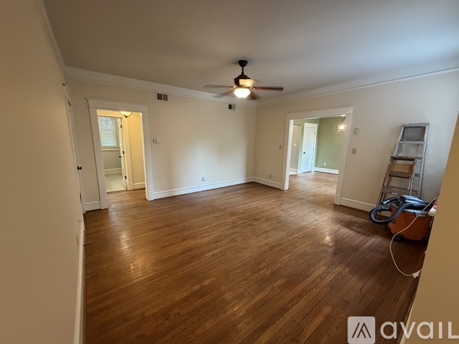 A room with wooden flooring and a ceiling fan.