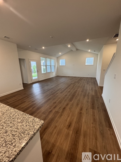 A spacious room with wooden flooring and a marble countertop.