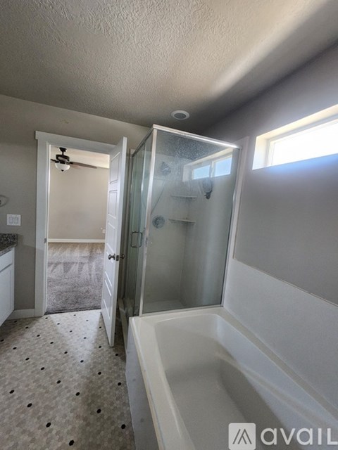 A bathroom with a glass shower door and a bathtub.