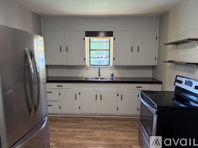 A kitchen with white cabinets and a black stove top oven.
