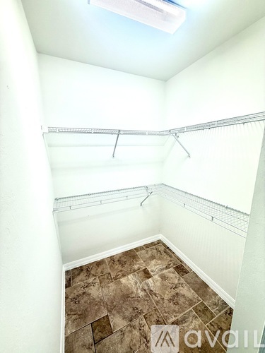 A room with a brown tile floor and white walls.